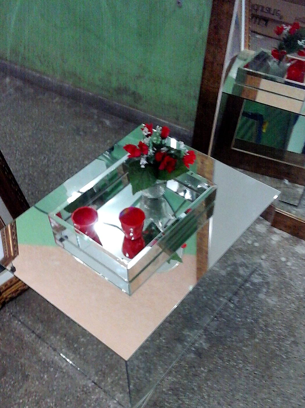 Mesa lateral espelhada com bandeja de espelho e flores vermelhas
